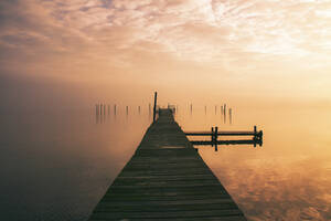 Jetty at sunrise with fog on the water